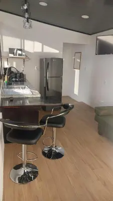 a kitchen with a counter and two bar stools at Mon Bellis in El Copey
