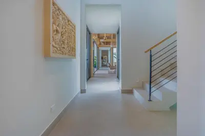 a hallway of a house with white walls and stairs at Casa Frenchie - by Pura Villas in Dominicalito