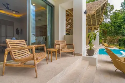 a patio with chairs and a table and a pool at Casa Frenchie - by Pura Villas in Dominicalito