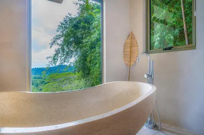 a bath tub in a bathroom with a large window at Casa Frenchie - by Pura Villas in Dominicalito