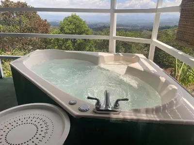 a bath tub filled with water in front of a window at Cabaña mirador Jacuzzi in Robles