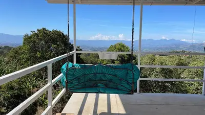 a swing on a porch with a view of the mountains at Cabaña mirador Jacuzzi in Robles