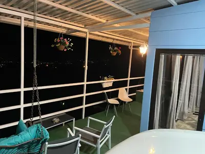 a room with chairs and a table on a balcony at Cabaña mirador Jacuzzi in Robles
