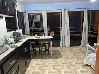 a kitchen with a table with chairs and a large window at Cabaña mirador Jacuzzi in Robles