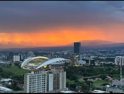 a view of a city at sunset with a building at Secrt 3014 in San José