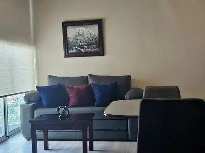 a living room with a couch with blue and red pillows at Secrt 3014 in San José