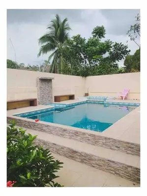 a large blue swimming pool in front of a building at Casa del Árbol in Quepos