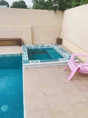 a small swimming pool with a pink chair and a pinkvisorvisor at Casa del Árbol in Quepos