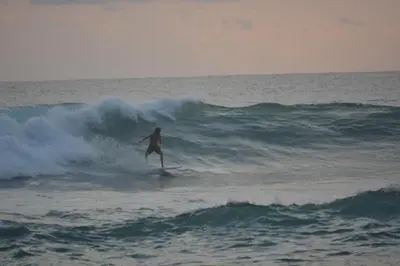 a person riding a wave on a surfboard in the ocean at Indigo Yoga Surf Resort in Mal País
