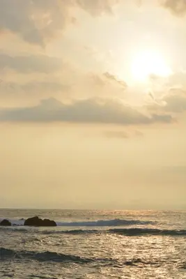 a sunset over the ocean with rocks in the water at Indigo Yoga Surf Resort in Mal País