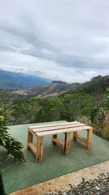 a wooden picnic table sitting on top of a hill at Cabaña Vista de Oro 1 in Paraíso