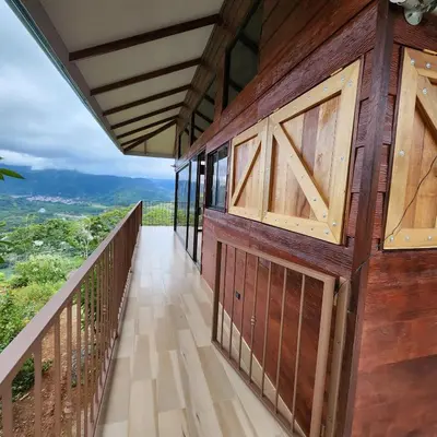 a balcony of a house with wooden doors at Cabaña Vista de Oro 1 in Paraíso