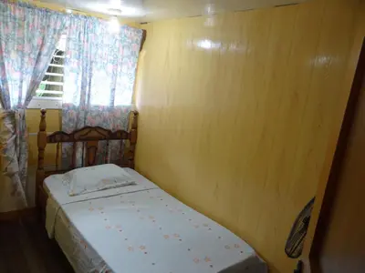 a small bedroom with a bed and a window at Hotel Rosa De Sharon in Marsella