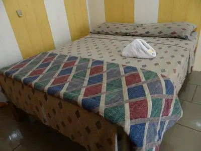 a bed with a quilt on top of it at Hotel Rosa De Sharon in Marsella