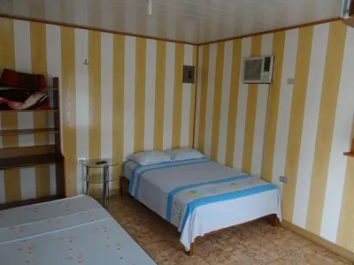 a bedroom with a bed in a room with striped walls at Hotel Rosa De Sharon in Marsella