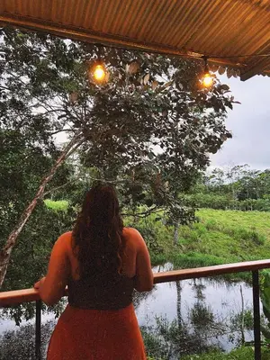 a woman sitting on a fence looking at a river at Rincón Sereno San Carlos in La Marina