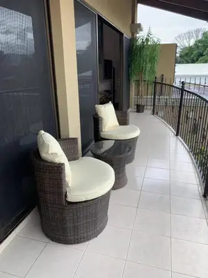 a balcony with wicker chairs and tables on a building at Luxury Apt, fully equipped, near to SJO airport in Alajuela City