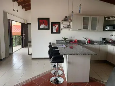 a kitchen with a counter and some chairs in it at Luxury Apt, fully equipped, near to SJO airport in Alajuela City