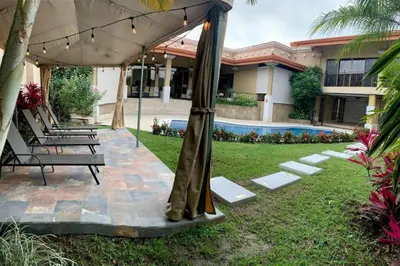 a group of benches under an umbrella in a yard at Luxury Apt, fully equipped, near to SJO airport in Alajuela City