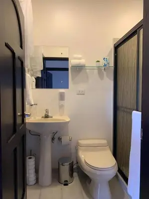a white bathroom with a toilet and a sink at Luxury Apt, fully equipped, near to SJO airport in Alajuela City