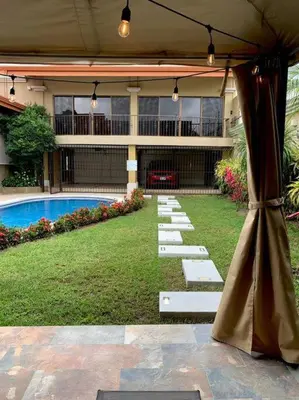 a patio with an umbrella in front of a building at Luxury Apt, fully equipped, near to SJO airport in Alajuela City