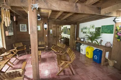 a room with wooden chairs and tables in a building at Bosque de Paz Reserva Biologica in Toro Amarillo