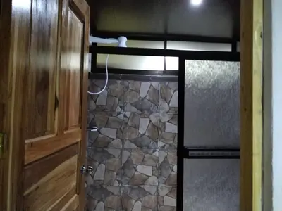 a kitchen with a stove and a stone wall at Casa La Montaña in Sámara