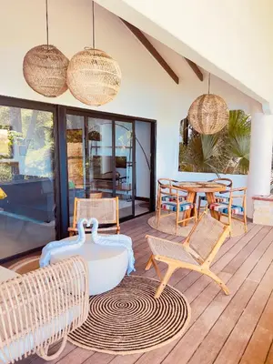 a living room with rattan chairs and a table at Tinamaste in Uvita