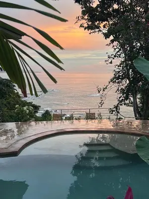 a swimming pool with a view of the ocean at Tinamaste in Uvita