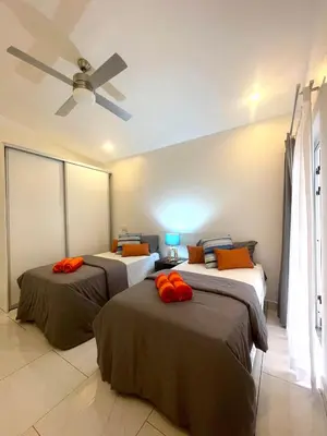 three beds in a room with a ceiling fan at Casa Frangipani in Santa Rosa de Tamarindo in Santa Cruz