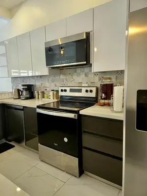 a kitchen with white cabinets and a stove top oven at Casa Frangipani in Santa Rosa de Tamarindo in Santa Cruz