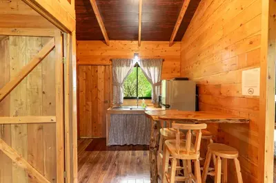 a kitchen with a bar in a wooden cabin at Cabaña El Manzano: Vistas increíbles y Mirador in Turrialba