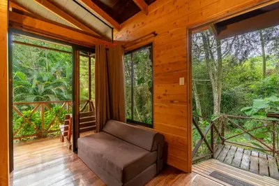 a room with a couch and large windows at Cabaña El Manzano: Vistas increíbles y Mirador in Turrialba