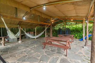 a patio with two picnic tables and hammocks at Cabaña El Manzano: Vistas increíbles y Mirador in Turrialba