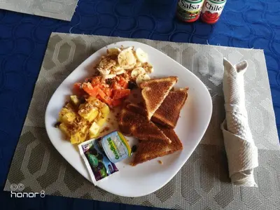 a plate of breakfast food with toast and scrambled eggs at Out of Bounds Boutique Hotel in San José