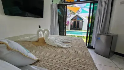 two white swans towels sitting on top of a bed at Alborada Boutique Stay in Uvita