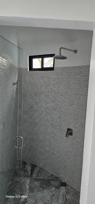 a bathroom with a shower with a window at Alborada Boutique Stay in Uvita
