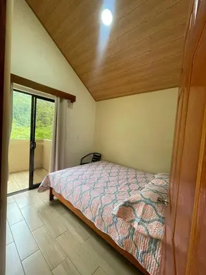 a bedroom with a bed and a large window at Casa Colibrí in Bijagua