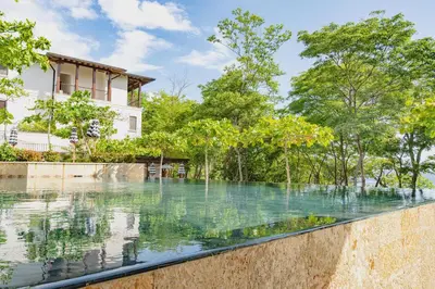 a swimming pool in front of a house with trees at Seaside Escape At Las Catalinas in Playa Danta