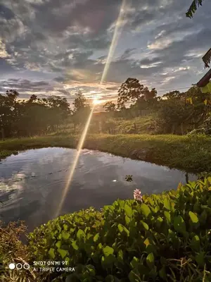 a sunset over a pond with the sun shining at Casa Luz de Luna in Paraíso