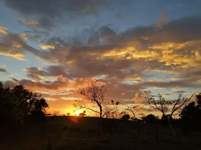 a sunset over a field with trees in the foreground at Casa Luz de Luna in Paraíso