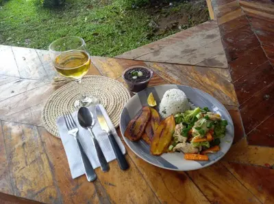 a plate of food on a table with a glass of wine at Casa Luz de Luna in Paraíso
