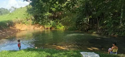 two women and a child standing in a river at Arenal Nephelium Country Home, Refugio rural con piscina, jacuzzi y balcón con hermosas vistas al Volcán Arenal, en una finca privada in Fortuna