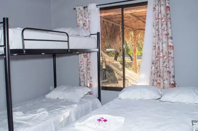 two bunk beds in a room with a window at Guaitil Chorotega House, acogedora y tranquila in Santa Cruz