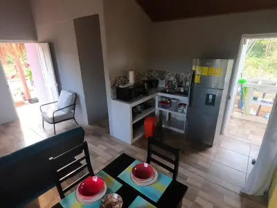 a kitchen with a refrigerator and a table in a room at Guaitil Chorotega House, acogedora y tranquila in Santa Cruz