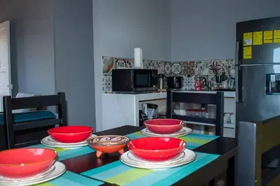 a kitchen with red bowls and plates on a table at Guaitil Chorotega House, acogedora y tranquila in Santa Cruz