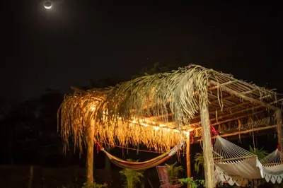 a thatched roof with lights on it at night at Guaitil Chorotega House, acogedora y tranquila in Santa Cruz
