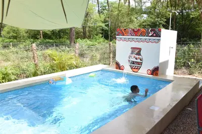 a boy in a swimming pool in a backyard at Guaitil Chorotega House, acogedora y tranquila in Santa Cruz
