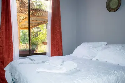 a bed with towels on it in front of a window at Guaitil Chorotega House, acogedora y tranquila in Santa Cruz