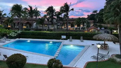 a large swimming pool in front of a house at Stylish 2-Bedroom Beach Condo with Ocean-View Deck, Lush Pool Area & 2-Minute Walk to Flamingo Beach in Playa Flamingo